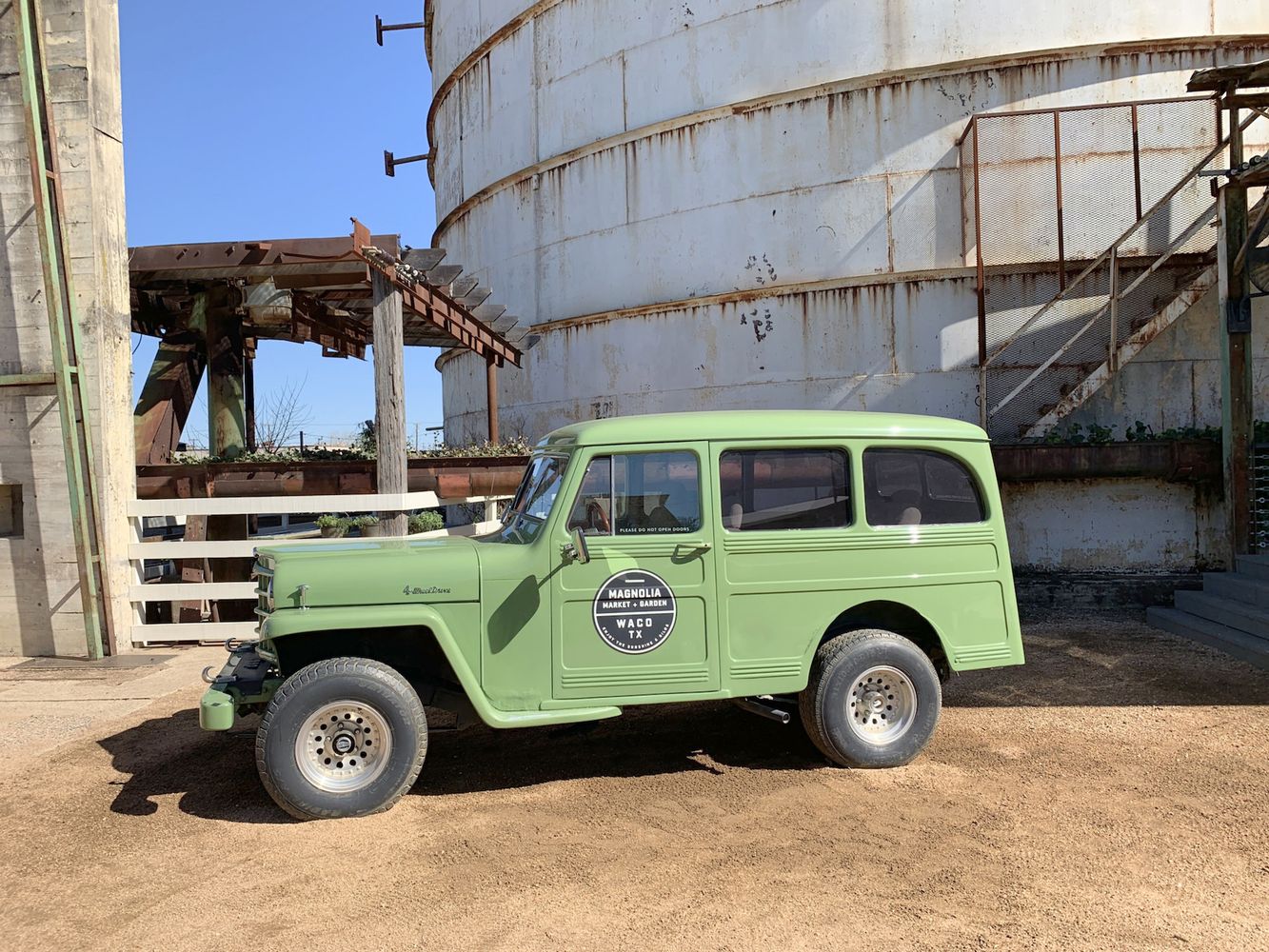 Green Car in front of the Silos at Magnolia Market